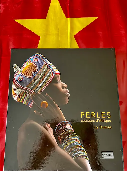 Perles d'Afrique modèle coiffé d'un chapeau en perles et portant une multitude de bracelets en perles
